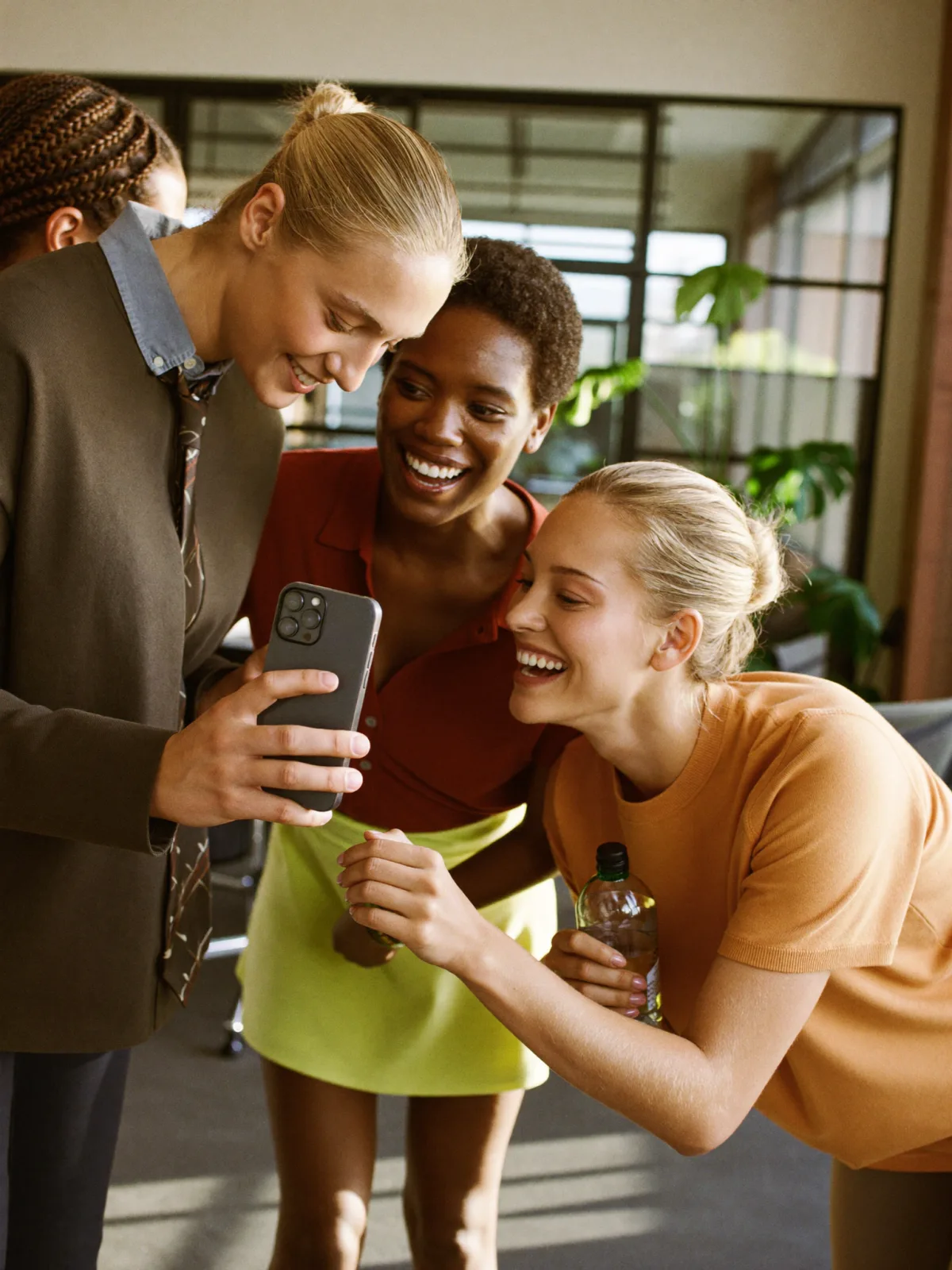 A team of colleagues celebrating a wellness challenge win together on a phone