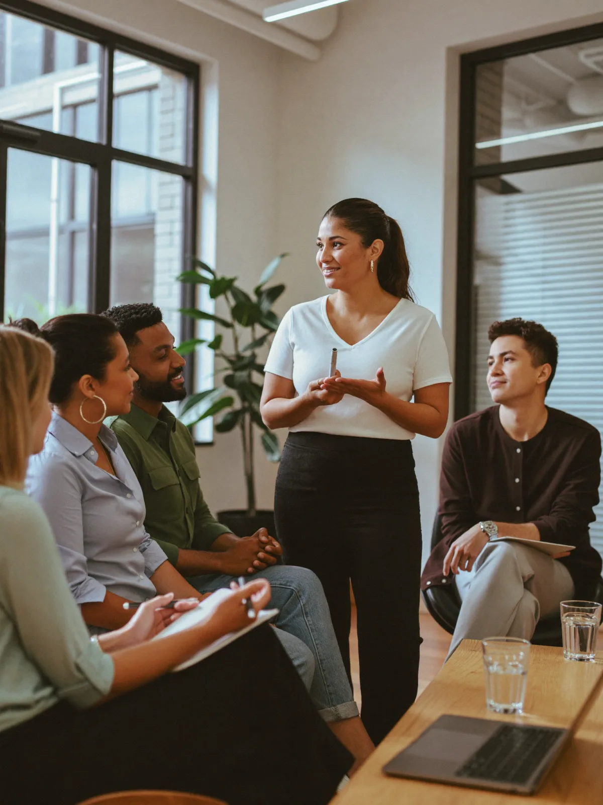 A wellness coach leading a live workshop for engaged employees in a bright modern office